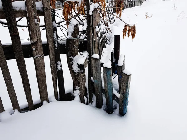 Cerca de madeira velha bonita no fundo da neve no inverno — Fotografia de Stock