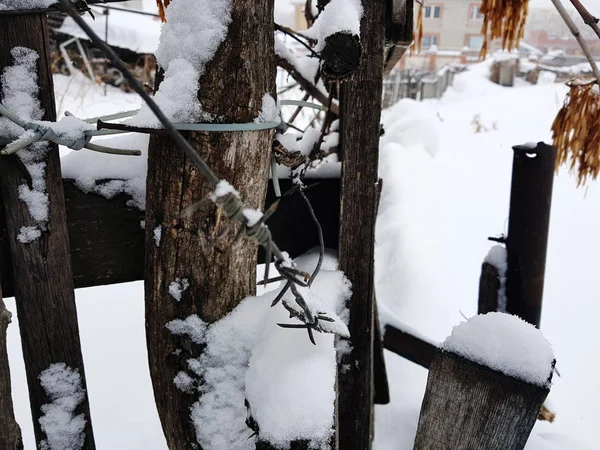Schöner alter Holzzaun vor dem Hintergrund des Schnees im Winter — Stockfoto