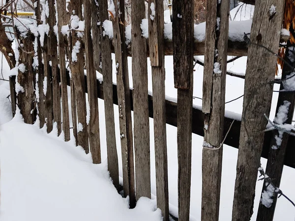 Belle vieille clôture en bois sur fond de neige en hiver — Photo