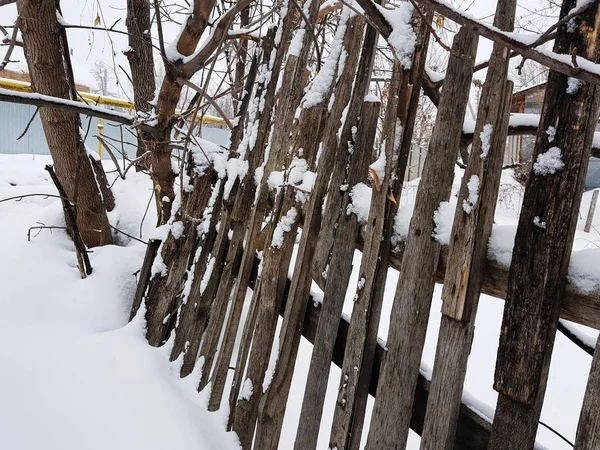 Mooie oude houten hek op de achtergrond van de sneeuw in de winter — Stockfoto