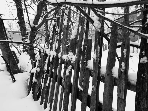 Beautiful old wooden fence on the background of snow in winter — Stock Photo, Image