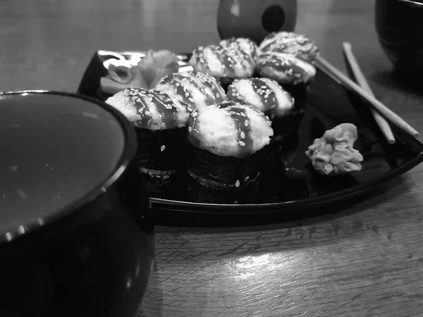 Όμορφη νόστιμα ψωμάκια σε ένα μαύρο πιάτο με σάλτσα σόγιας και chopsticks — Φωτογραφία Αρχείου