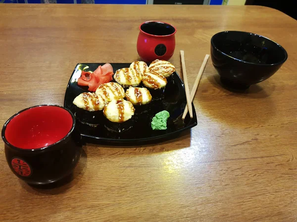 美丽美味的卷在一个黑色的盘子与酱油和筷子 — 图库照片