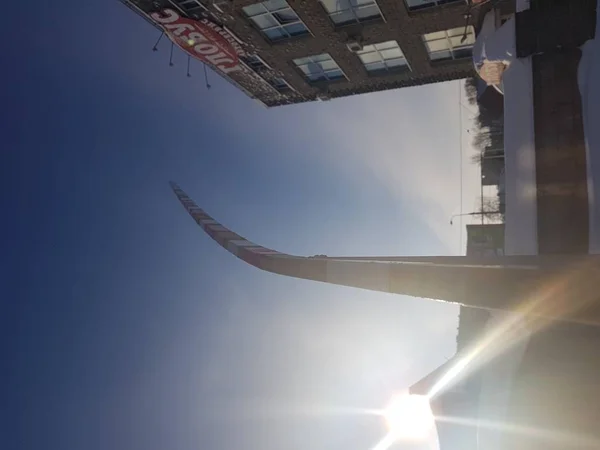 Broken curved barrier against the blue sky and the building