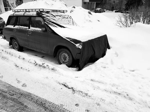 Krásné staré auto s krytem na kapotě ve sněhu — Stock fotografie
