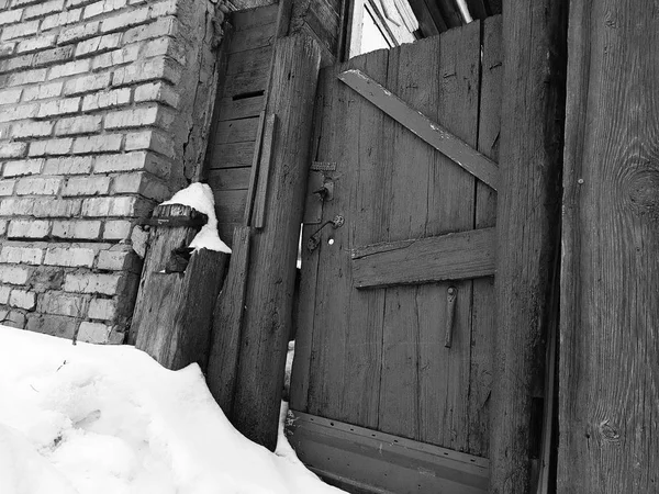 Puerta vieja con una cerca en la entrada a una casa de ladrillo en el fondo de la nieve en invierno —  Fotos de Stock