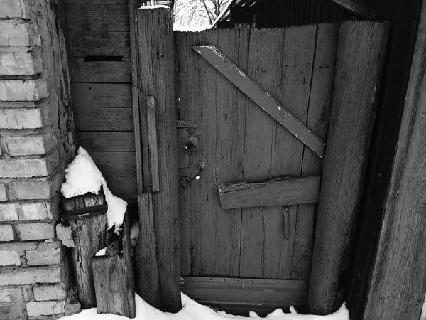 在冬天下雪的背景下, 砖房入口处有栅栏的旧大门 — 图库照片