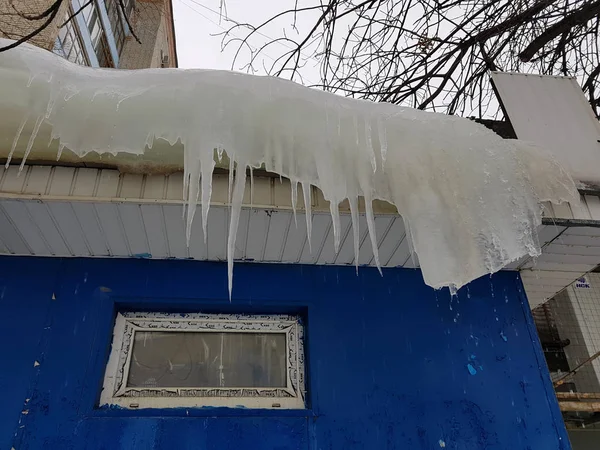 Niebezpieczne sople i lód na dachu wiosną lub zimą — Zdjęcie stockowe