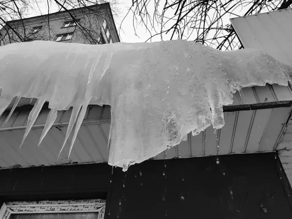 Carámbanos peligrosos y hielo en el techo en primavera o invierno — Foto de Stock