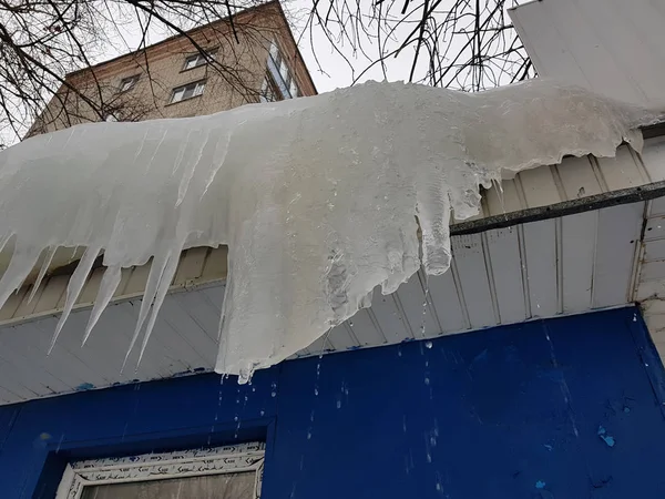 Veszélyes jégcsapok és jég a tetőn tavasszal vagy télen — Stock Fotó