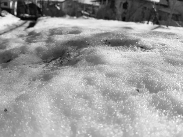 Neve brilha nos raios do sol no fundo do oleoduto e casas no inverno ou na primavera — Fotografia de Stock