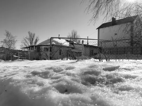 Nieve brilla en los rayos del sol en el fondo de la tubería y casas en el invierno o la primavera —  Fotos de Stock