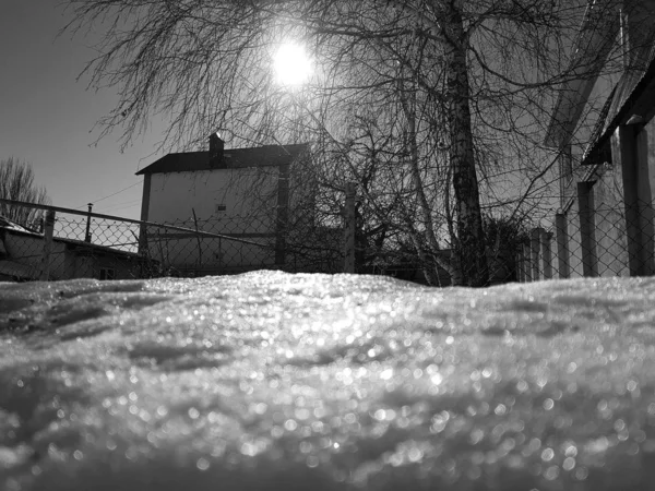 Nieve brilla en los rayos del sol en el fondo de la tubería y casas en el invierno o la primavera —  Fotos de Stock