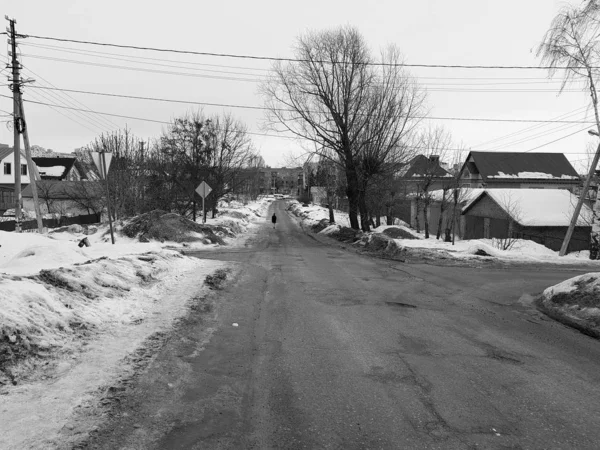 Homem solitário em uma estrada vazia no inverno ou na primavera — Fotografia de Stock