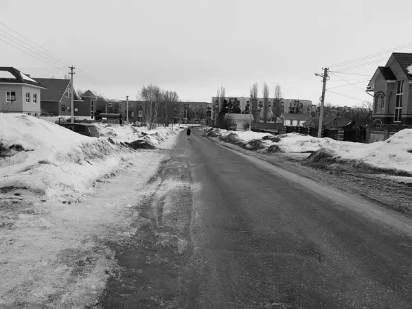 Самотній чоловік на порожній дорозі взимку або навесні — стокове фото