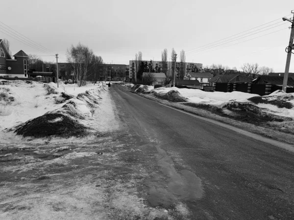 Homem solitário em uma estrada vazia no inverno ou na primavera — Fotografia de Stock