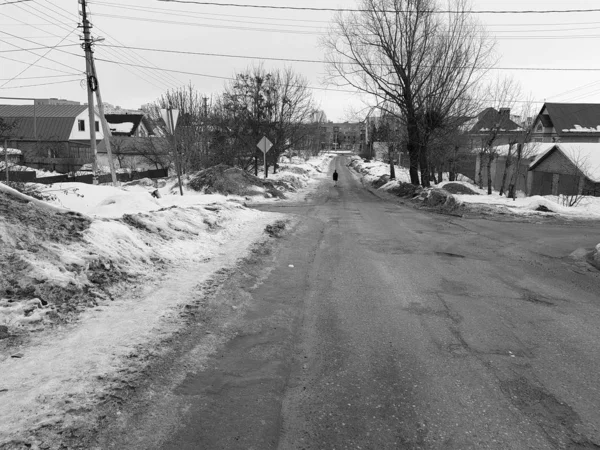 Eenzame man op een lege weg in de winter of de lente — Stockfoto