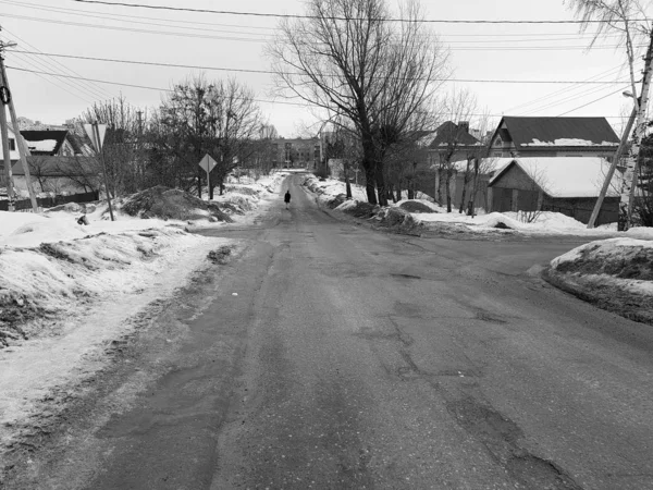 Hombre solitario en un camino vacío en invierno o primavera —  Fotos de Stock