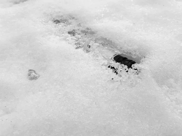 Schneeflasche und Kaugummi auf dem Schnee im Winter oder Frühling — Stockfoto