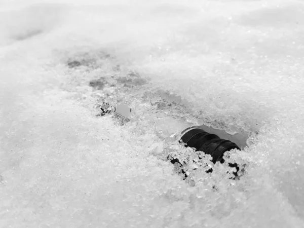 Hóüveg és gumi a hóban télen vagy tavasszal — Stock Fotó