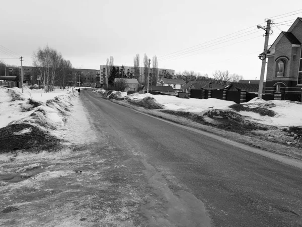Hombre solitario en un camino vacío en invierno o primavera —  Fotos de Stock