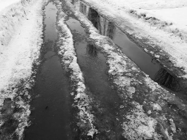 Schöne Pfützen mit Eiskruste, Schnee und Reflexion im Winter oder Frühling — Stockfoto