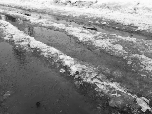 Schöne Pfützen mit Eiskruste, Schnee und Reflexion im Winter oder Frühling — Stockfoto