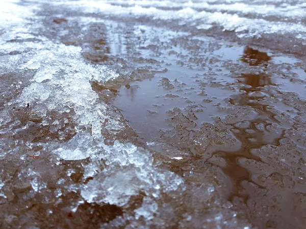 Schöne Pfützen mit Eiskruste, Schnee und Reflexion im Winter oder Frühling — Stockfoto