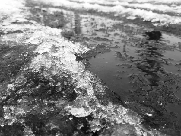 Schöne Pfützen mit Eiskruste, Schnee und Reflexion im Winter oder Frühling — Stockfoto