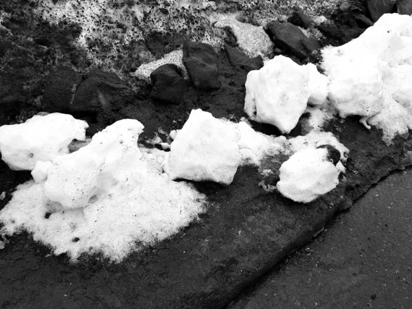 Bílý sníh na pozadí bláta a černého tání sněhu na silnici v zimě nebo na jaře — Stock fotografie