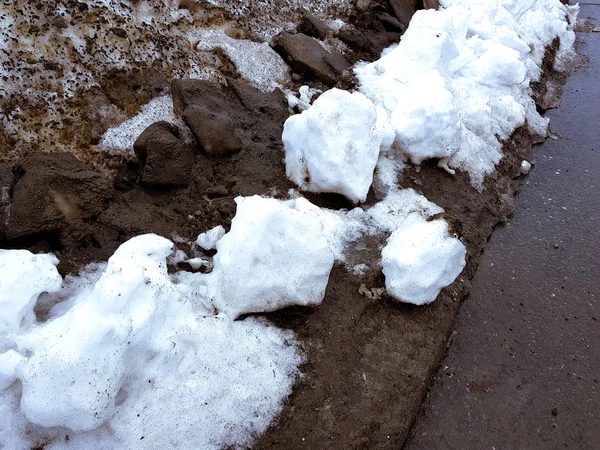 Neige blanche sur fond de boue et de neige fondante noire sur la route en hiver ou au printemps — Photo