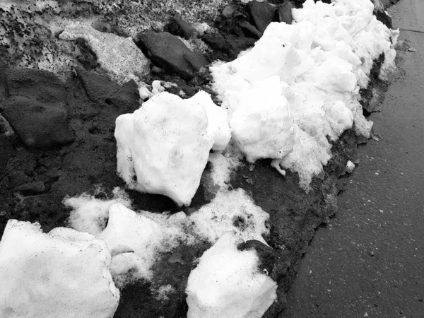 White snow on the background of mud and black melting snow on the road in winter or spring — 스톡 사진