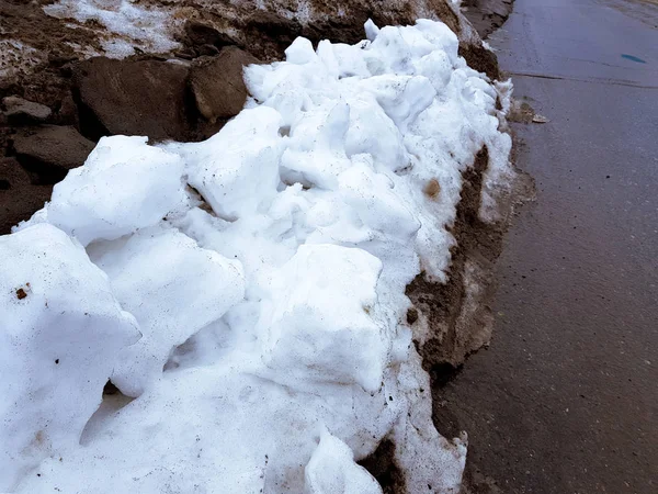 Neige blanche sur fond de boue et de neige fondante noire sur la route en hiver ou au printemps — Photo