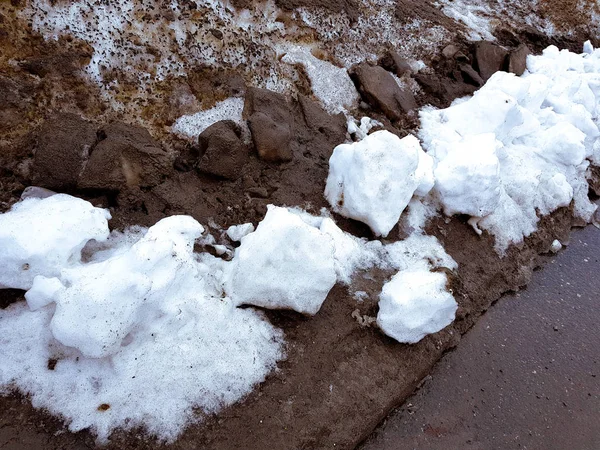 Biały śnieg na tle błota i czarny topniejący śnieg na drodze zimą lub wiosną — Zdjęcie stockowe