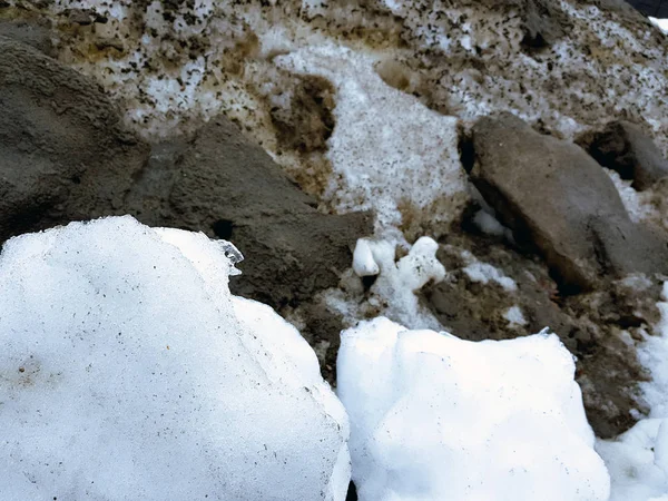 Neve branca no fundo de lama e neve negra derretida na estrada no inverno ou na primavera — Fotografia de Stock