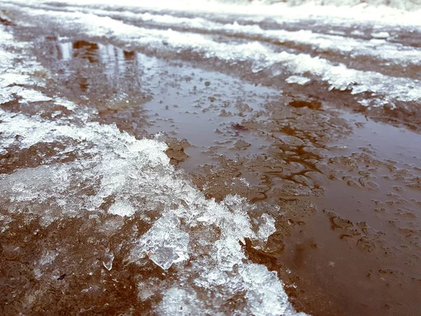 Bellissime pozzanghere con crosta di ghiaccio, neve e riflessione in inverno o in primavera — Foto Stock