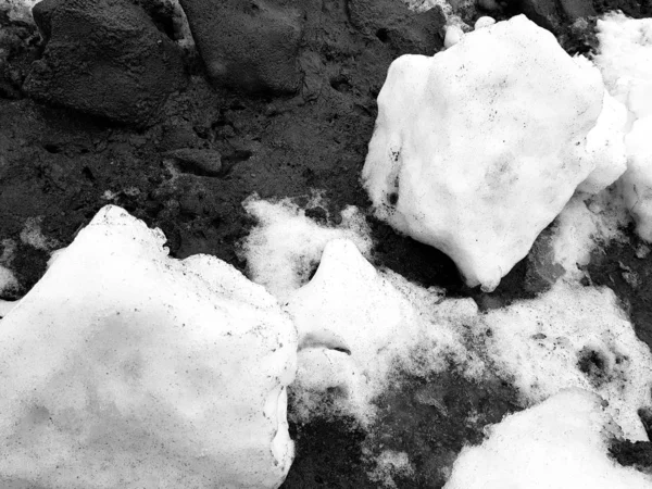 Bílý sníh na pozadí bláta a černého tání sněhu na silnici v zimě nebo na jaře — Stock fotografie
