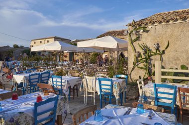 İtalya, Sicilya, Marzamemi (Siracusa eyaleti); 10 Temmuz 2018, insanlar ve küçük kasaba - yazı işleri eski kesiminde restoranlarda