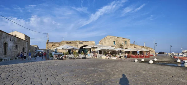 İtalya, Sicilya, Marzamemi (Siracusa eyaleti); 10 Temmuz 2018, insanlar ve küçük kasaba - yazı işleri eski kesiminde restoranlarda