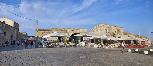 İtalya, Sicilya, Marzamemi (Siracusa eyaleti); 10 Temmuz 2018, insanlar ve küçük kasaba - yazı işleri eski kesiminde restoranlarda