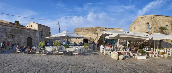 İtalya, Sicilya, Marzamemi (Siracusa eyaleti); 10 Temmuz 2018, insanlar ve küçük kasaba - yazı işleri eski kesiminde restoranlarda