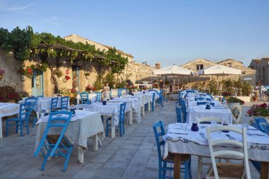 İtalya, Sicilya, Marzamemi (Siracusa eyaleti); 10 Temmuz 2018, insanlar ve küçük kasaba - yazı işleri eski kesiminde restoranlarda