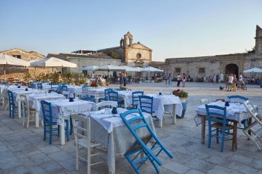 İtalya, Sicilya, Marzamemi (Siracusa eyaleti); 10 Temmuz 2018, insanlar ve küçük kasaba - yazı işleri eski kesiminde restoranlarda