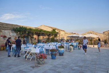İtalya, Sicilya, Marzamemi (Siracusa eyaleti); 10 Temmuz 2018, insanlar ve küçük kasaba - yazı işleri eski kesiminde restoranlarda
