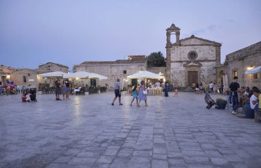 İtalya, Sicilya, Marzamemi (Siracusa eyaleti); 10 Temmuz 2018, insanlar ve gün batımında - editoryal küçük şehrin eski kısmı restoranlarda