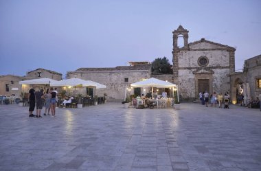 İtalya, Sicilya, Marzamemi (Siracusa eyaleti); 10 Temmuz 2018, insanlar ve gün batımında - editoryal küçük şehrin eski kısmı restoranlarda