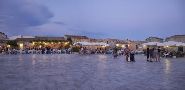 İtalya, Sicilya, Marzamemi (Siracusa eyaleti); 10 Temmuz 2018, insanlar ve gün batımında - editoryal küçük şehrin eski kısmı restoranlarda