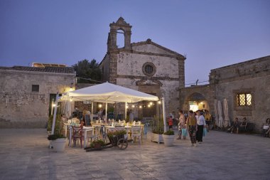 İtalya, Sicilya, Marzamemi (Siracusa eyaleti); 10 Temmuz 2018, insanlar ve gün batımında - editoryal küçük şehrin eski kısmı restoranlarda