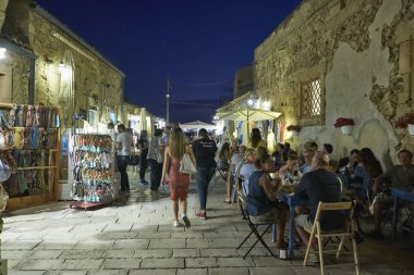 İtalya, Sicilya, Marzamemi (Siracusa eyaleti); 10 Temmuz 2018, insanlar ve gün batımında - editoryal küçük şehrin eski kısmı restoranlarda