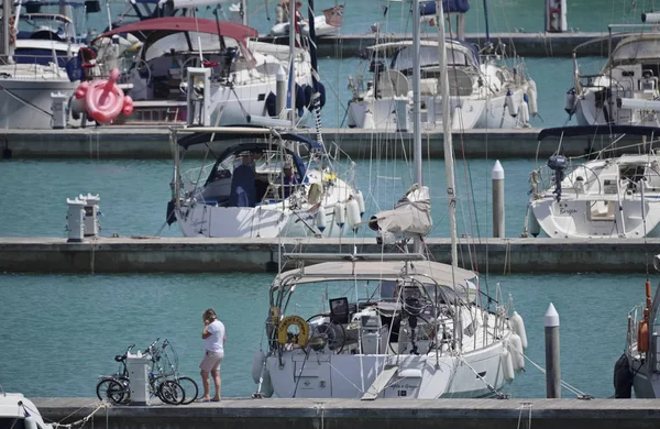 İtalya, Sicilya, Akdeniz, Marina di Ragusa; 23 Temmuz 2018, insanlar ve Yelkenli tekneler limanda - Editörden